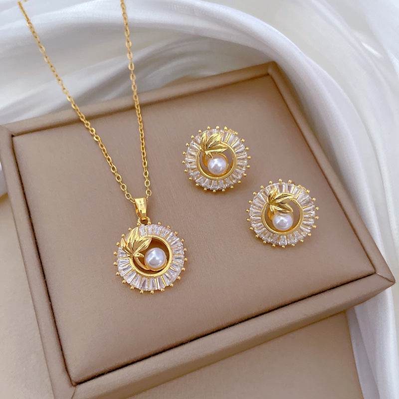 Set de collar y pendientes dorados con hoja y efecto perla